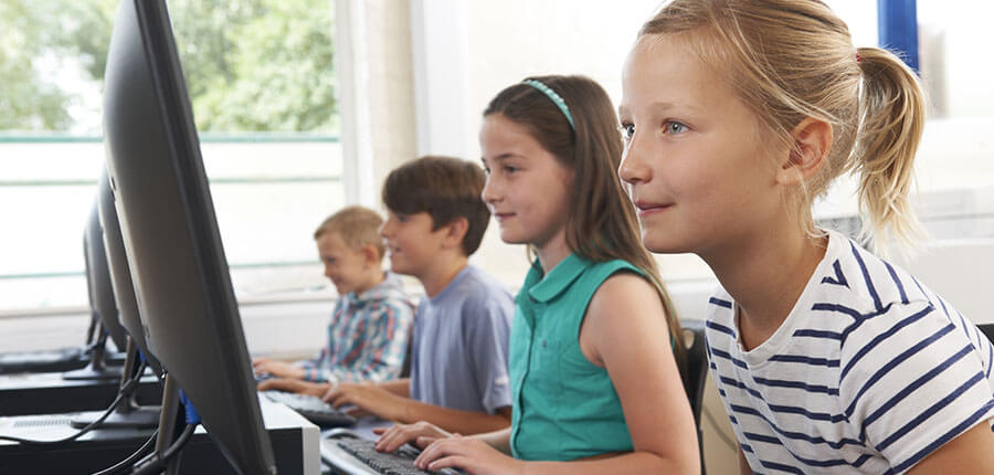 Schüler vor Computer sitzen in Programmierkurs